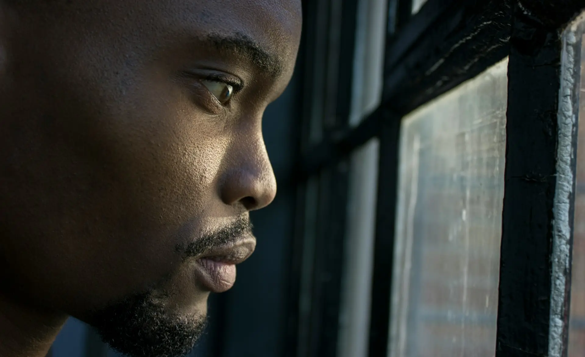 man near glass window pane